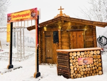 Einseite Almhüttenfassade Netto Olympia-Event Cortina