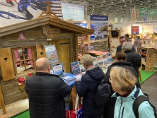 Prospektpräsentation am Messestand Urlaub in den Alpen
