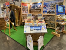 Prospektpräsentation am Messestand Urlaub in den Alpen