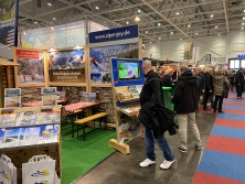 Prospektpräsentation am Messestand Urlaub in den Alpen
