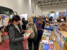 Prospektpräsentation am Messestand Urlaub in den Alpen