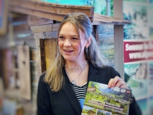 Prospektpräsentation am Messestand Urlaub in den Alpen