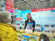 Prospektpräsentation am Messestand Urlaub in den Alpen