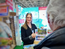 Prospektpräsentation am Messestand Urlaub in den Alpen