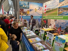Prospektpräsentation am Messestand Urlaub in Deutschland