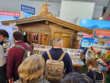 Prospektpräsentation am Messestand Urlaub in den Alpen