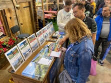 Prospektpräsentation am Messestand Urlaub in den Alpen