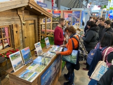 Prospektpräsentation am Messestand Urlaub in den Alpen