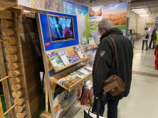 Prospektpräsentation am Messestand Urlaub in den Alpen