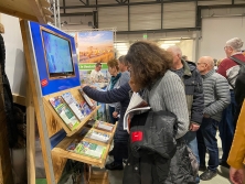 Prospektpräsentation am Messestand Urlaub in den Alpen