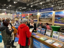 Prospektpräsentation am Messestand Urlaub in den Alpen
