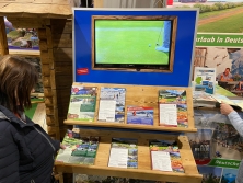 Prospektpräsentation am Messestand Urlaub in den Alpen