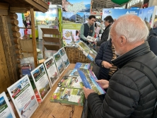 Prospektpräsentation am Messestand Urlaub in den Alpen