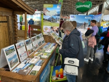 Prospektpräsentation am Messestand Urlaub in den Alpen