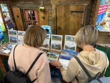 Prospektpräsentation am Messestand Urlaub in den Alpen