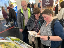 Prospektpräsentation am Messestand Urlaub in den Alpen