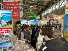 Prospektpräsentation am Messestand Urlaub in den Alpen