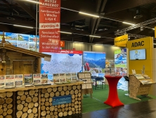 Prospektpräsentation am Messestand Urlaub in den Alpen