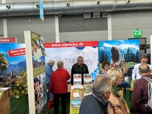 Prospektpräsentation am Messestand Urlaub in den Alpen