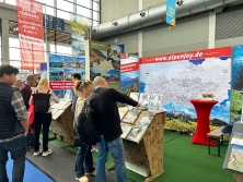 Prospektpräsentation am Messestand Urlaub in den Alpen