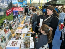 Prospektpräsentation am Messestand Urlaub in den Alpen