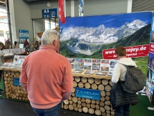 Prospektpräsentation am Messestand Urlaub in den Alpen