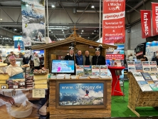 Prospektpräsentation am Messestand Urlaub in den Alpen