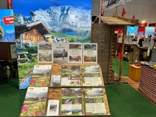 Prospektpräsentation am Messestand Urlaub in den Alpen
