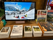 Prospektpräsentation am Messestand Urlaub in den Alpen