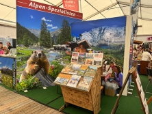 Prospektpräsentation am Messestand Urlaub in den Alpen