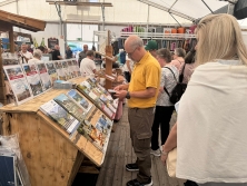 Prospektpräsentation am Messestand Urlaub in den Alpen