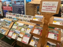 Prospektpräsentation am Messestand Urlaub in den Alpen