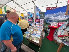 Prospektpräsentation am Messestand Urlaub in den Alpen
