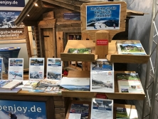 Prospektpräsentation am Messestand Urlaub in den Alpen