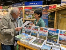 Prospektpräsentation am Messestand Urlaub in den Alpen