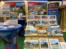 Prospektpräsentation am Messestand Urlaub in den Alpen