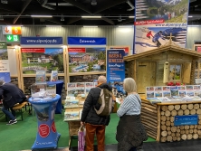 Prospektpräsentation am Messestand Urlaub in den Alpen