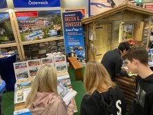 Prospektpräsentation am Messestand Urlaub in den Alpen