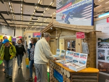 Prospektpräsentation am Messestand Urlaub in den Alpen