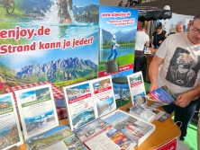 Prospektpräsentation am Messestand Urlaub in den Alpen