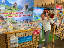 Prospektpräsentation am Messestand Urlaub in den Alpen