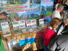 Prospektpräsentation am Messestand Urlaub in den Alpen