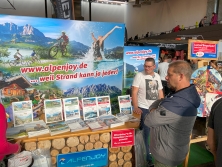 Prospektpräsentation am Messestand Urlaub in den Alpen