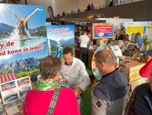 Prospektpräsentation am Messestand Urlaub in den Alpen