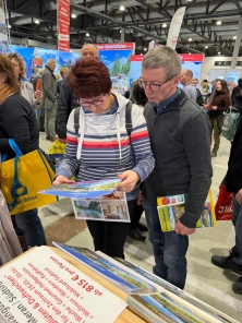 Prospektpräsentation am Messestand Urlaub in den Alpen