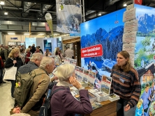 Prospektpräsentation am Messestand Urlaub in den Alpen