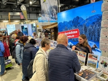Prospektpräsentation am Messestand Urlaub in den Alpen