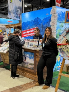Prospektpräsentation am Messestand Urlaub in den Alpen