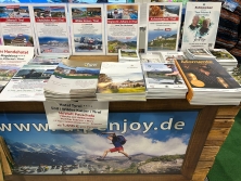 Prospektpräsentation am Messestand Urlaub in den Alpen