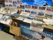 Prospektpräsentation am Messestand Urlaub in den Alpen